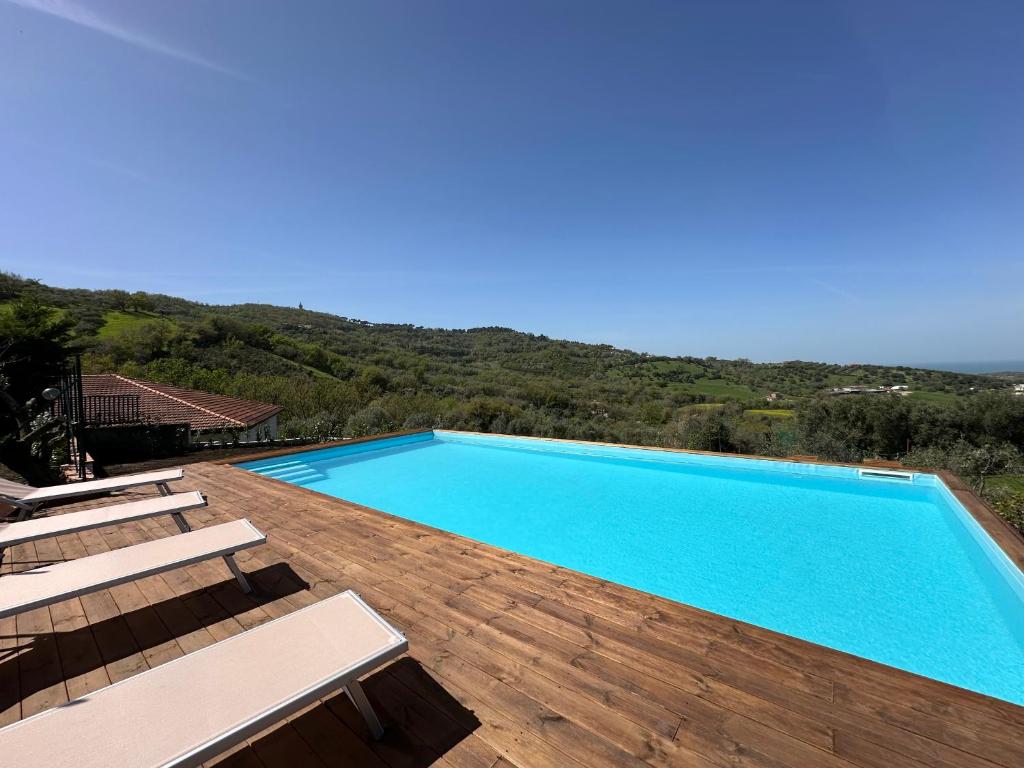 a swimming pool on a wooden deck with a view at Il Poggio del Cilento Country House in Agropoli