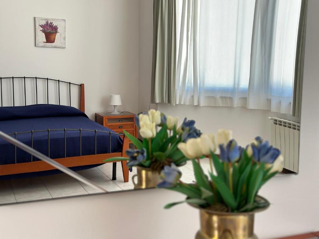 ein Schlafzimmer mit einem Bett und zwei Blumenvasen auf einem Tisch in der Unterkunft Antica Sorgente in Agropoli