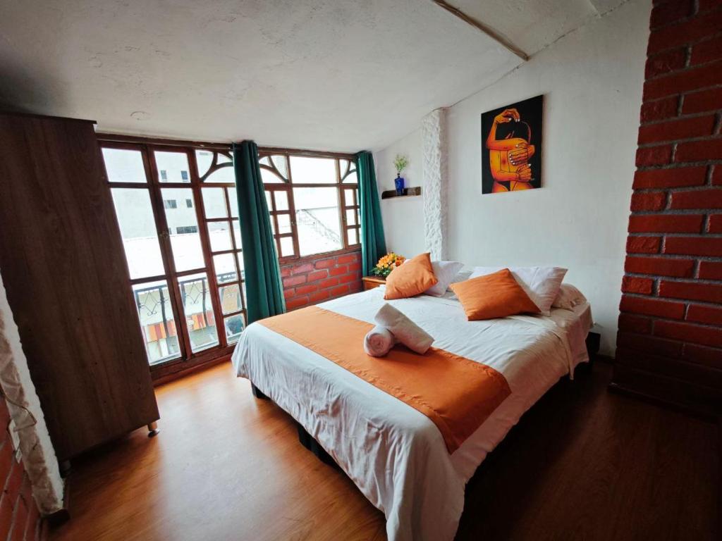 1 dormitorio con cama y ventana grande en Garden House Hostal, en Baños