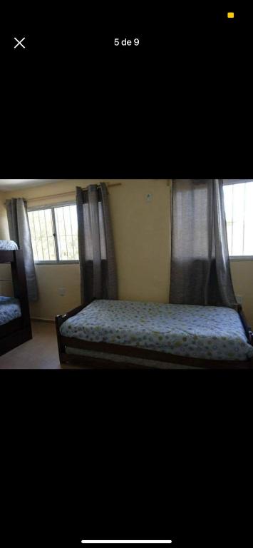 1 dormitorio con 1 cama y 2 ventanas en La Caprichosa, en San Luis
