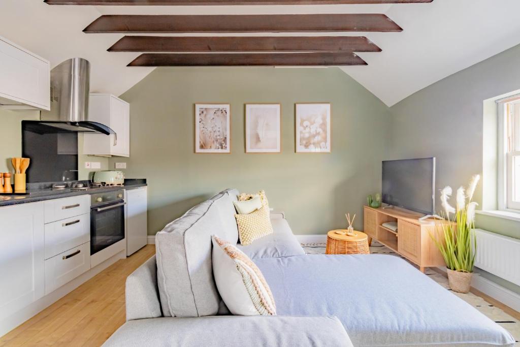 a living room with a couch and a kitchen at St James Lodge in Cheltenham