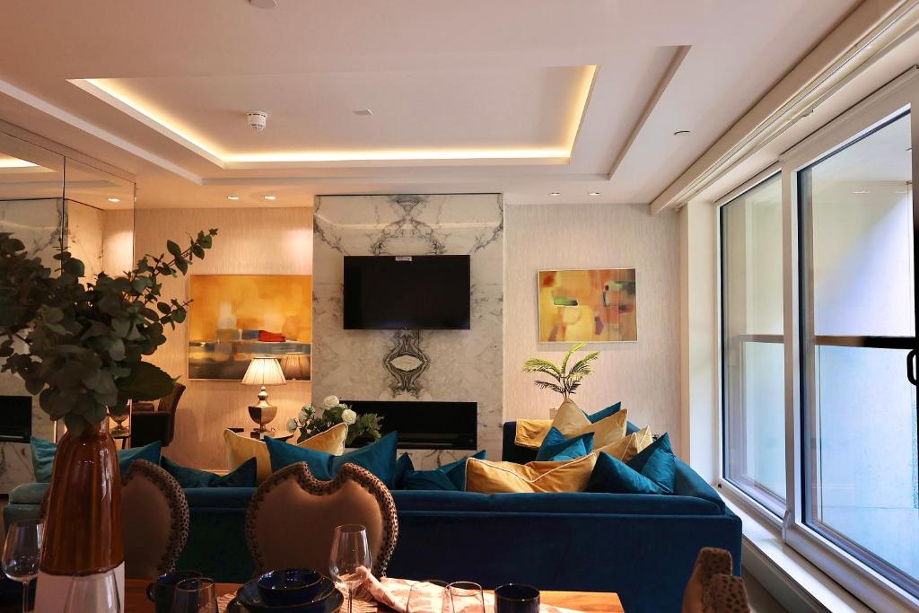 a living room with a blue couch and a tv at Luxury-high street Kensington-spacious-hydePark in London