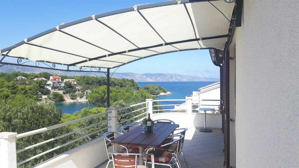 balcón con mesa y vistas al agua en Apartment With the Sea View en Basina