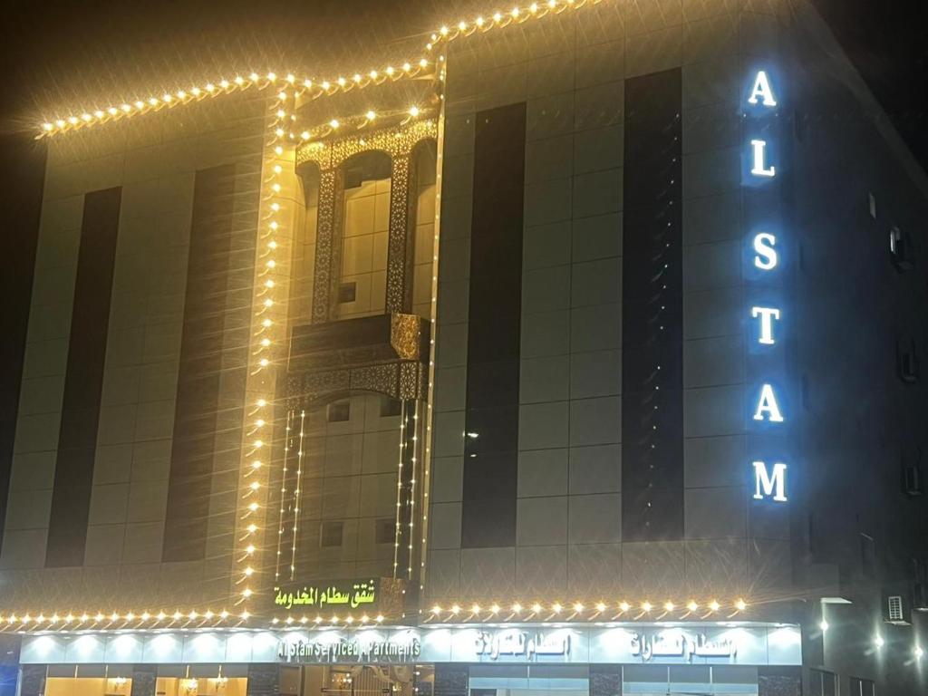 a large building with lights on it at night at شقق سطام المخدومة in Al Fayşalīyah