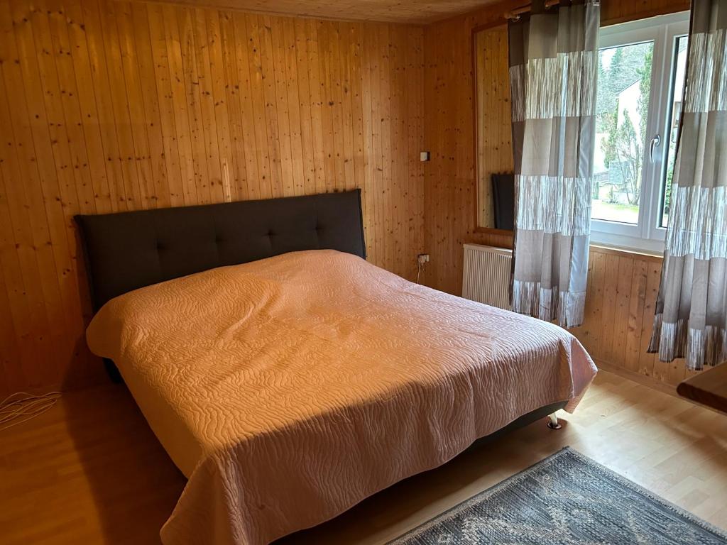 ein Schlafzimmer mit einem Bett in einem Zimmer mit Holzwänden in der Unterkunft Casa Cascatella in Augio
