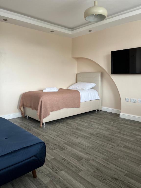 um quarto com uma cama e uma televisão de ecrã plano em Boutique Apartments em Londres