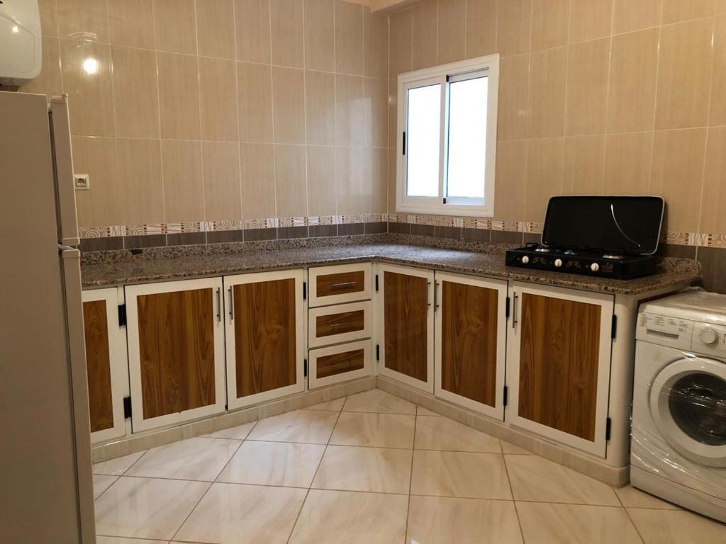 a kitchen with a sink and a washer and dryer at Residence al Rahma 03 in Monte ʼArrouit