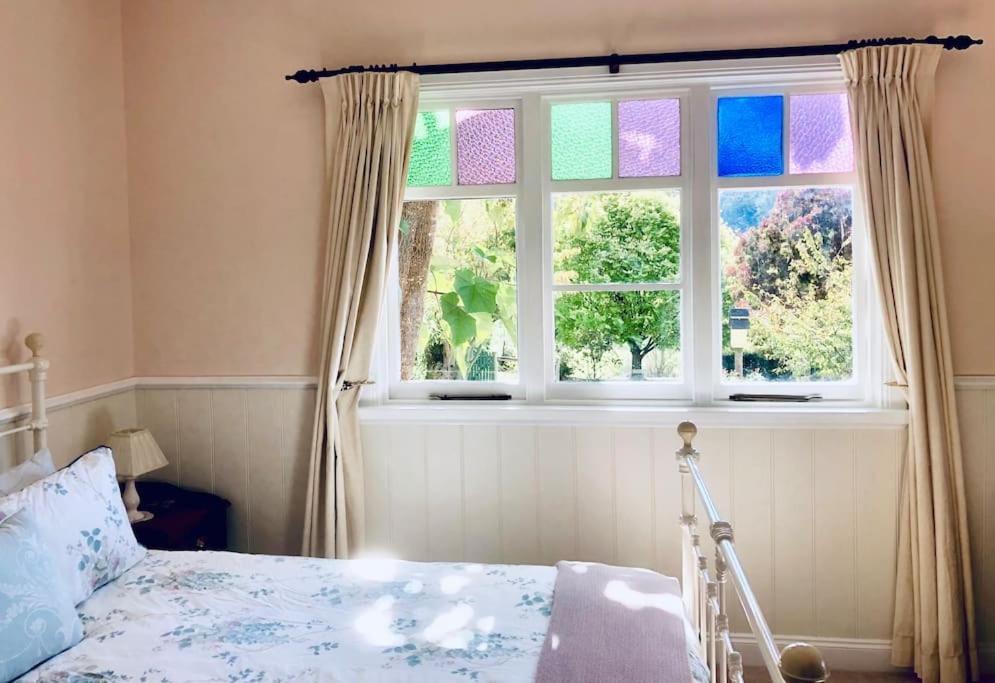 une chambre avec un lit et une fenêtre dans l'établissement Maple Hill Cottage, à Castle Forbes Bay