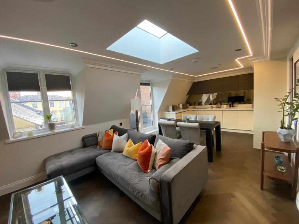 a living room with a couch and a kitchen at Beautiful Penthouse in centre of Winchester in Winchester