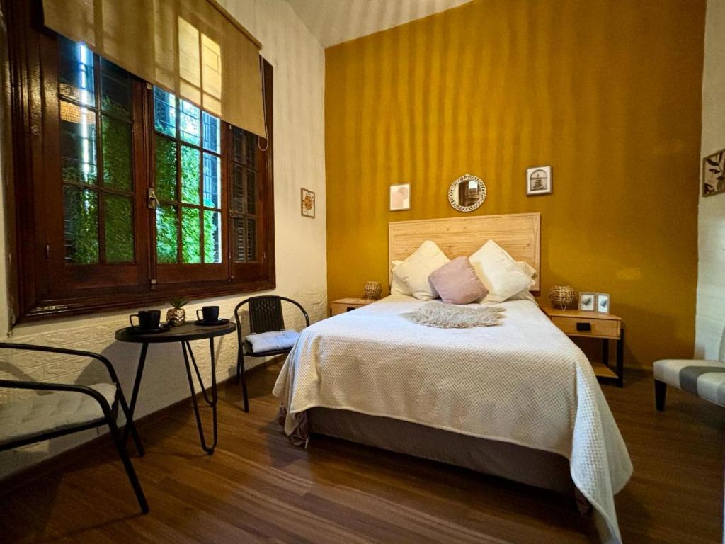 a bedroom with a bed and a yellow wall at Expreso trescrucesdos in Montevideo