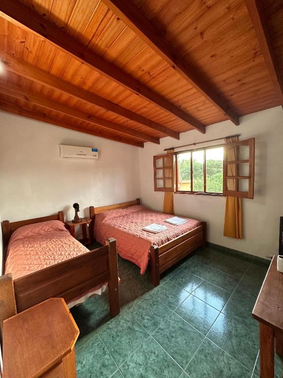 1 dormitorio con 2 camas y ventana en El Roble en Merlo