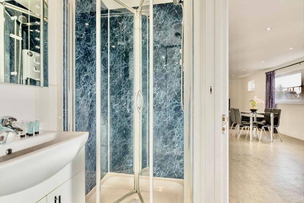 een badkamer met een glazen douche en een wastafel bij City Centre Cozy Studio flat Second Floor in Cambridge