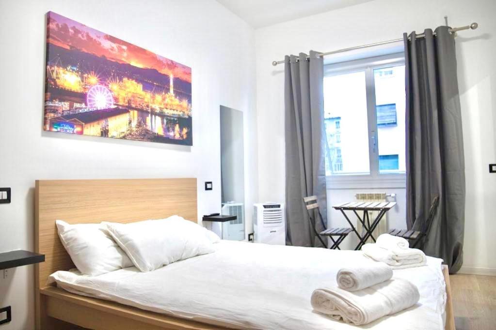 um quarto com uma cama grande e toalhas em Genova Suite em Génova