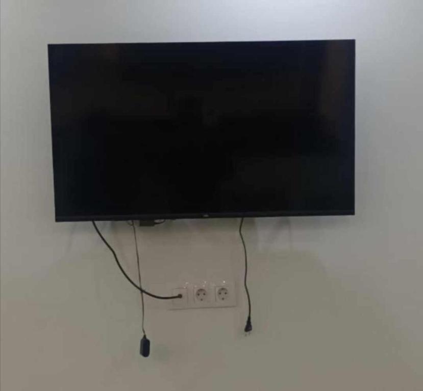 telewizor z płaskim ekranem wiszący na ścianie w obiekcie Fernand ville Oran w mieście Oran