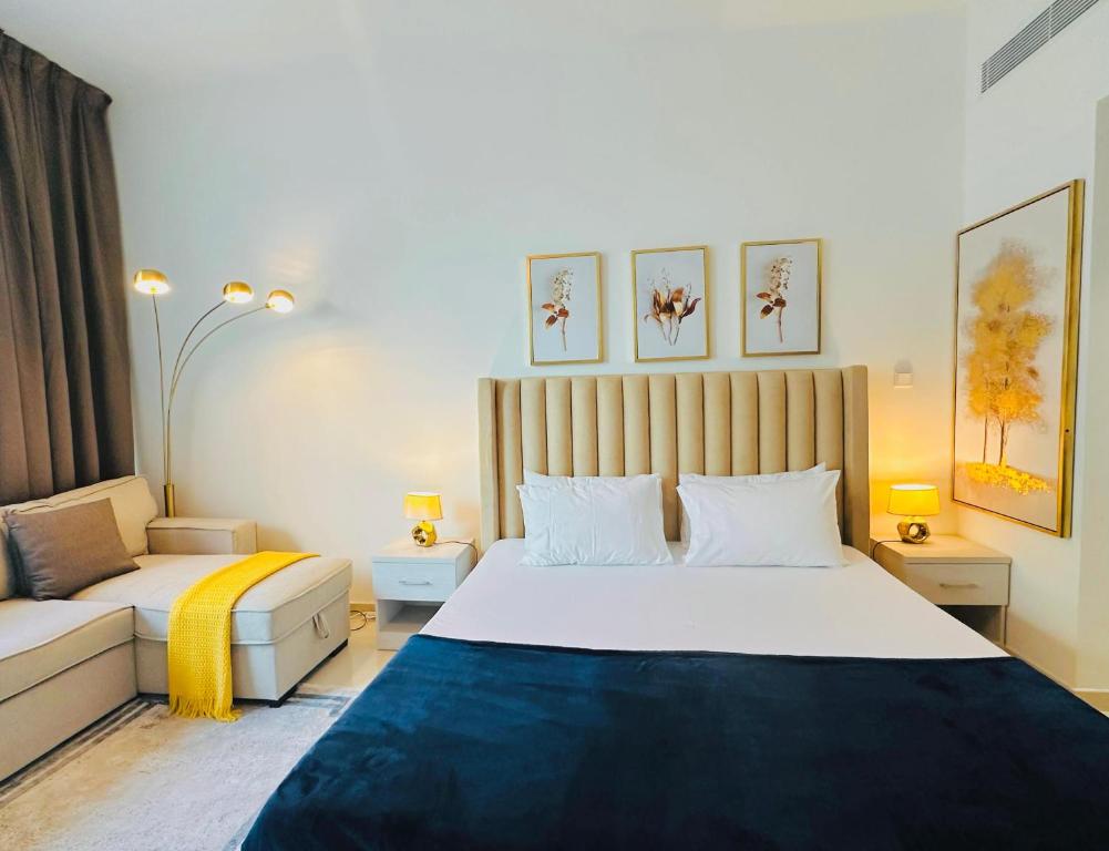 una camera con un grande letto e un divano di Luxurious studio apartment with private garden a Sharjah