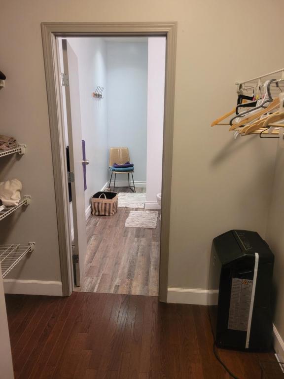 un couloir avec une porte s'ouvrant sur une chambre avec une chaise dans l'établissement Wissem, à Edmonton