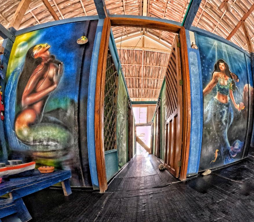 a hallway with a mural of mermaids on the wall at Cabaña la Gloria in San Onofre