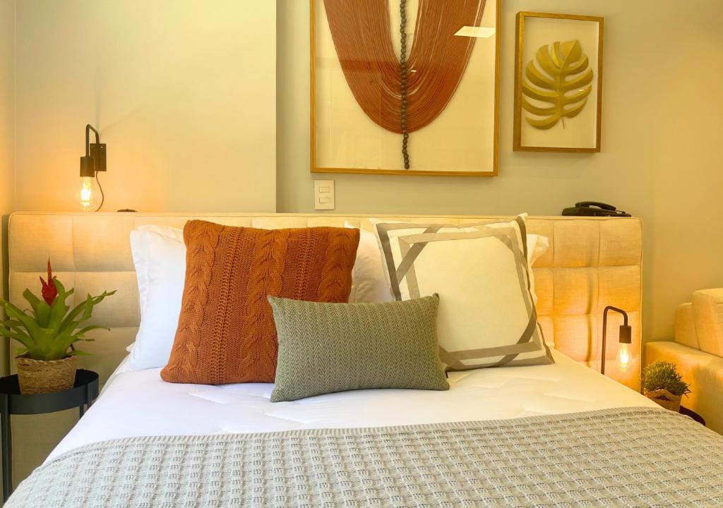 sypialnia z białym łóżkiem z poduszkami w obiekcie Loft luxuoso na Serra - Granja Brasil Resort w mieście Petrópolis