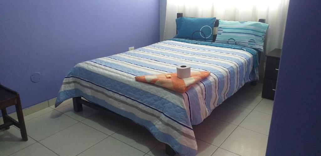 ein blaues Schlafzimmer mit einem Bett mit einer Kerze darauf in der Unterkunft PAKKARIN - HOTEL in Chachapoyas