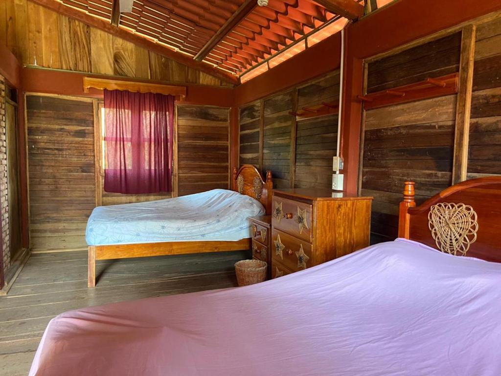 2 camas en una habitación con paredes de madera en CABAÑAS CEYTAKS, 