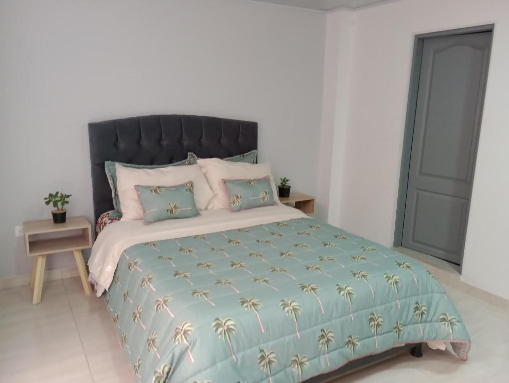 - une chambre avec un lit doté d'une couette et d'oreillers bleus dans l'établissement Aparta estudio Fontanar del río suba, à Bogotá