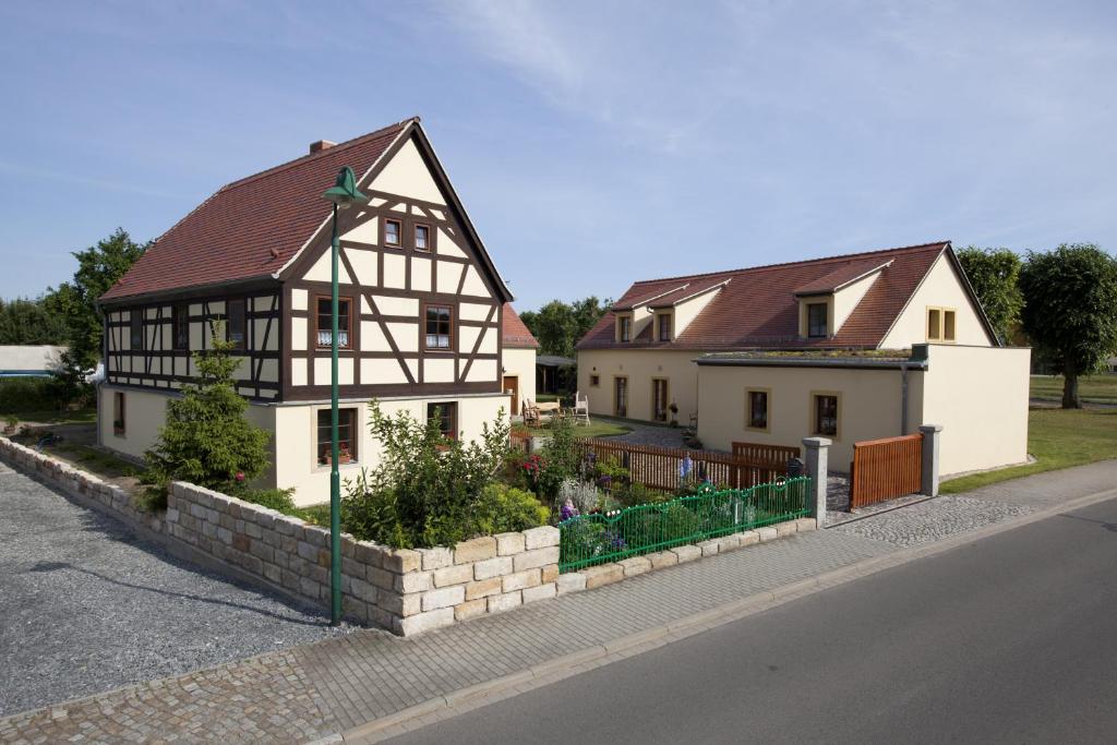 zwei weiße und schwarze Häuser an der Straßenseite in der Unterkunft Pension Alte Schmiede in Zabeltitz