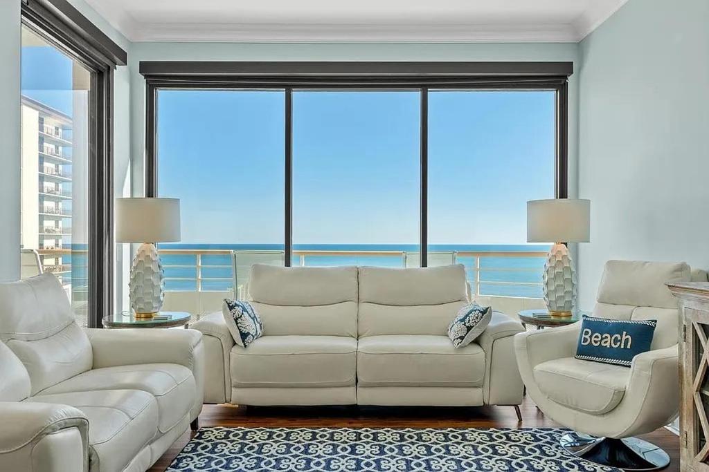 una sala de estar con sofás blancos y una ventana grande. en Penthouse North Myrtle Beach, en Myrtle Beach