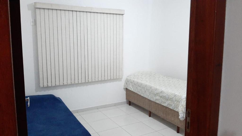 um pequeno quarto com uma cama e uma janela em Jockey Family_Suave em Vila Velha