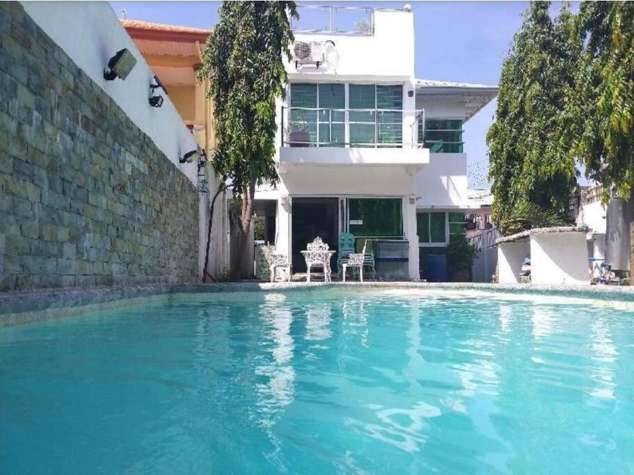 una piscina frente a una casa en White House near Thunderbird Resort, en Parian