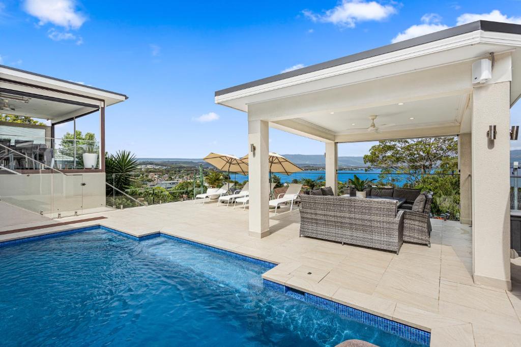 une image d'une maison avec une piscine dans l'établissement HEATed Pool, Lake & Beach, Luxury 5 B/R House, à Lake Illawarra