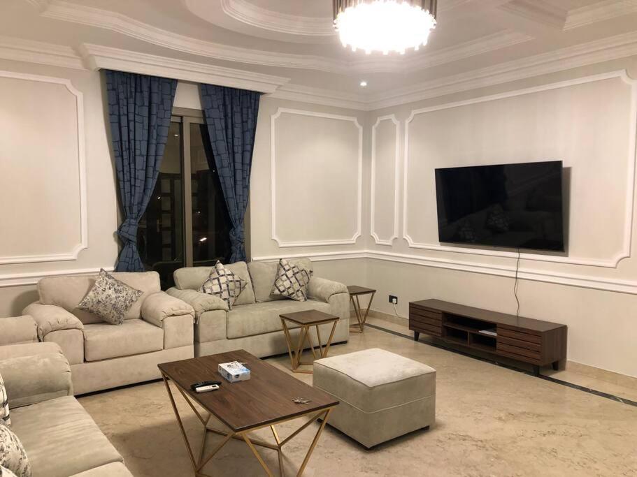 uma sala de estar com um sofá e uma televisão de ecrã plano em Distinctive chalet in Dur.Marina em Durat Alarous