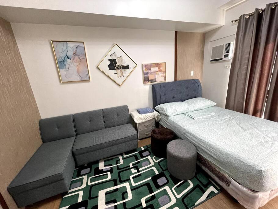 a small room with a bed and a couch at CityView Condo w/ balcony-14 in Cagayan de Oro