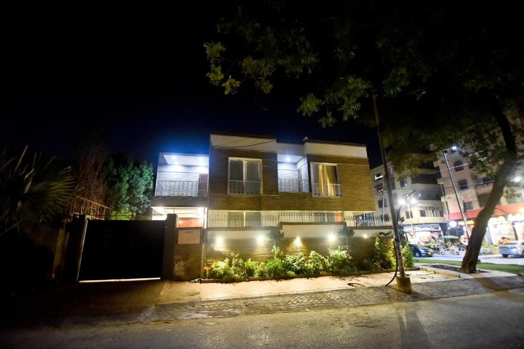 un edificio con luces delante de él por la noche en The Sandcastle en Karachi