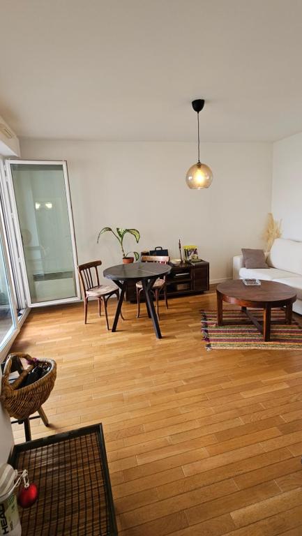 een woonkamer met een tafel en een bank bij Superb apartment next to Paris in Bois-Colombes