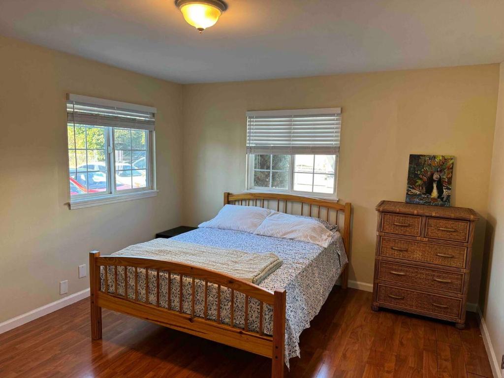 East Palo Alto的住宿－Private room near Facebook, Amazon, Stanford，一间卧室配有一张床、一个梳妆台和两个窗户。