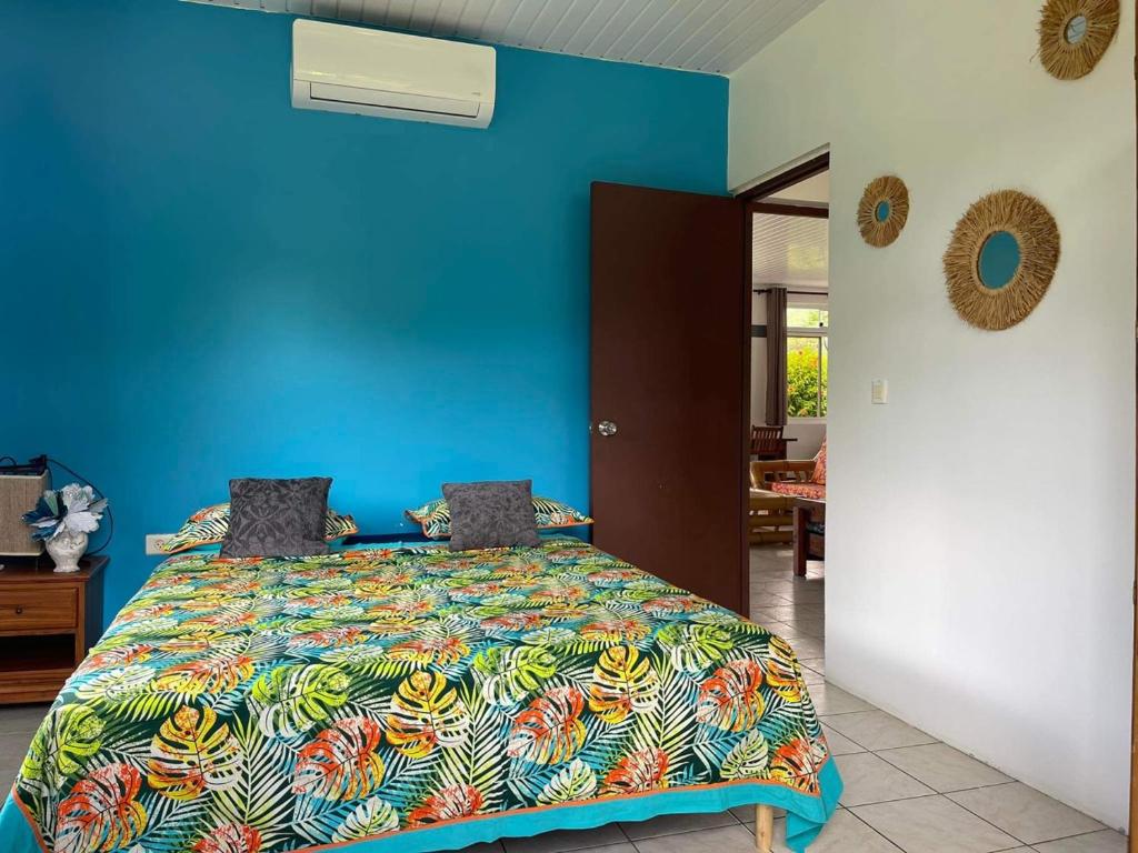 Dormitorio azul con cama con colcha colorida en H&R House en Tiva