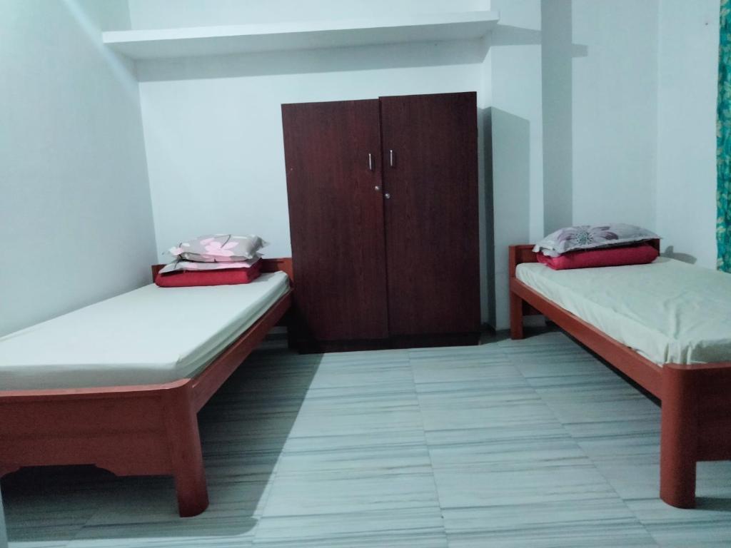 um quarto com duas camas e um armário em Moa's Nest em Dimāpur