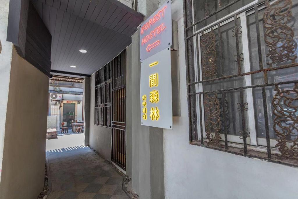 einen Flur mit einem Schild an der Seite eines Gebäudes in der Unterkunft One Forest Youth Hostel - The Bund Branch in Shanghai