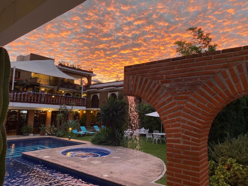 una casa con una pared de ladrillo y una piscina en Hotel Hacienda Ventana del Cielo, en Tepoztlán