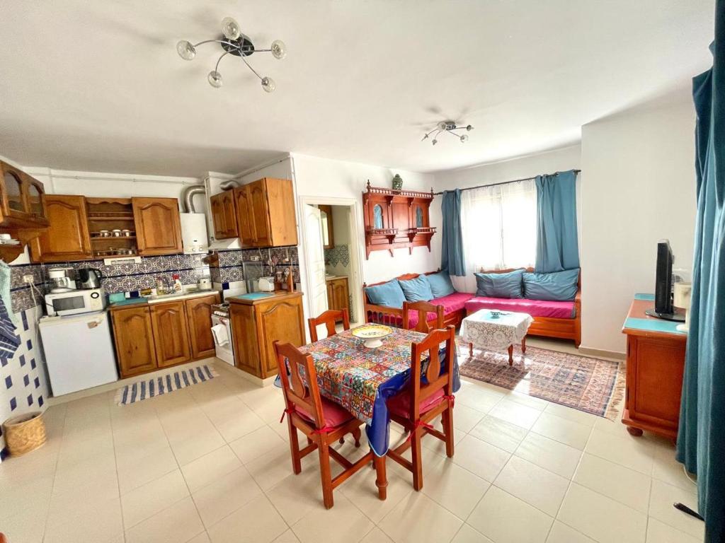 een keuken en een woonkamer met een tafel en een bank bij Le 5éme Penthouse cosy with sea view in Sousse