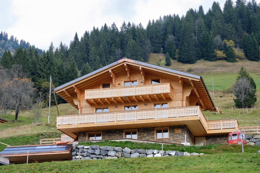 a large log house with a balcony on a hill at Chalet Capucchione in Les Diablerets