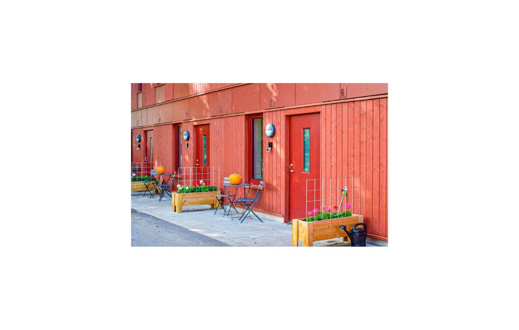 una fila de edificios rojos con mesas y sillas en Cozy Apartment In Frjestaden With Wifi, en Färjestaden