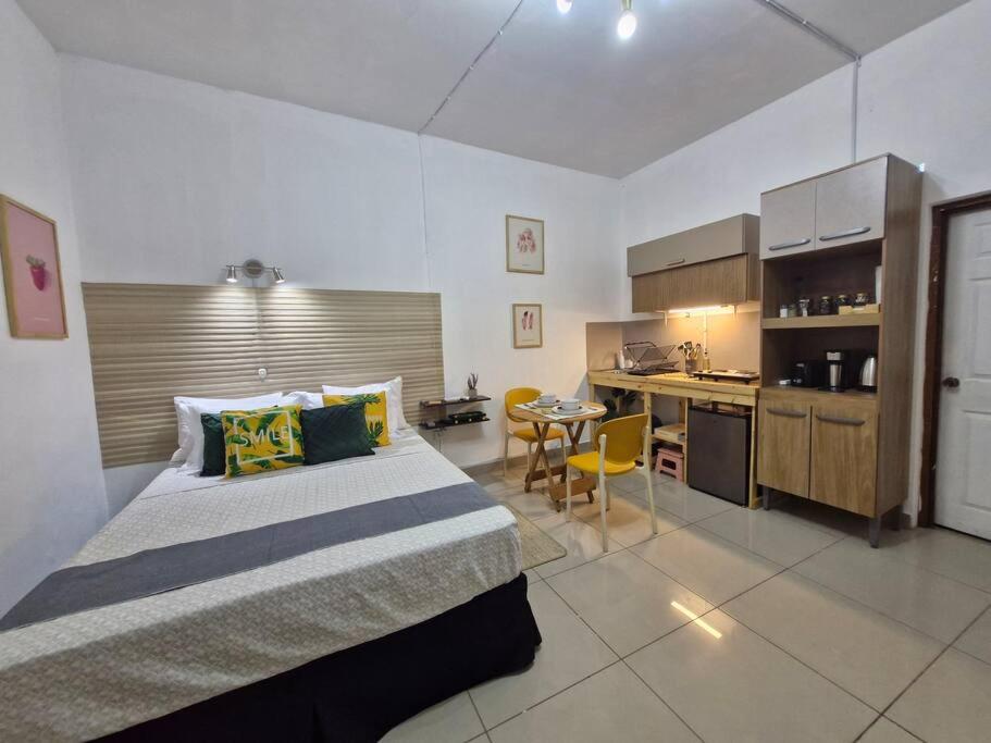 a bedroom with a large bed and a kitchen at 8 Beach Suite w/pool by Madrigera in La Libertad