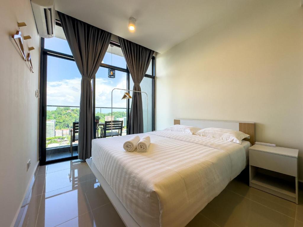 a bedroom with a large bed with two towels on it at Downtown Remin Suites at The Shore Kota Kinabalu in Kota Kinabalu