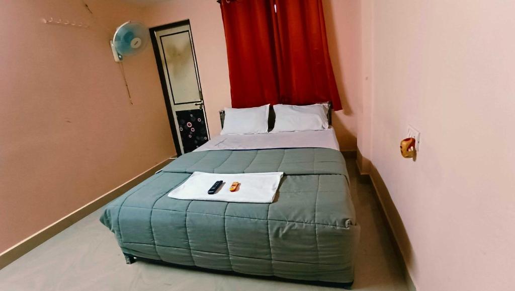 a small bedroom with a bed with a towel on it at OYO Ajay Bording in Nagpur