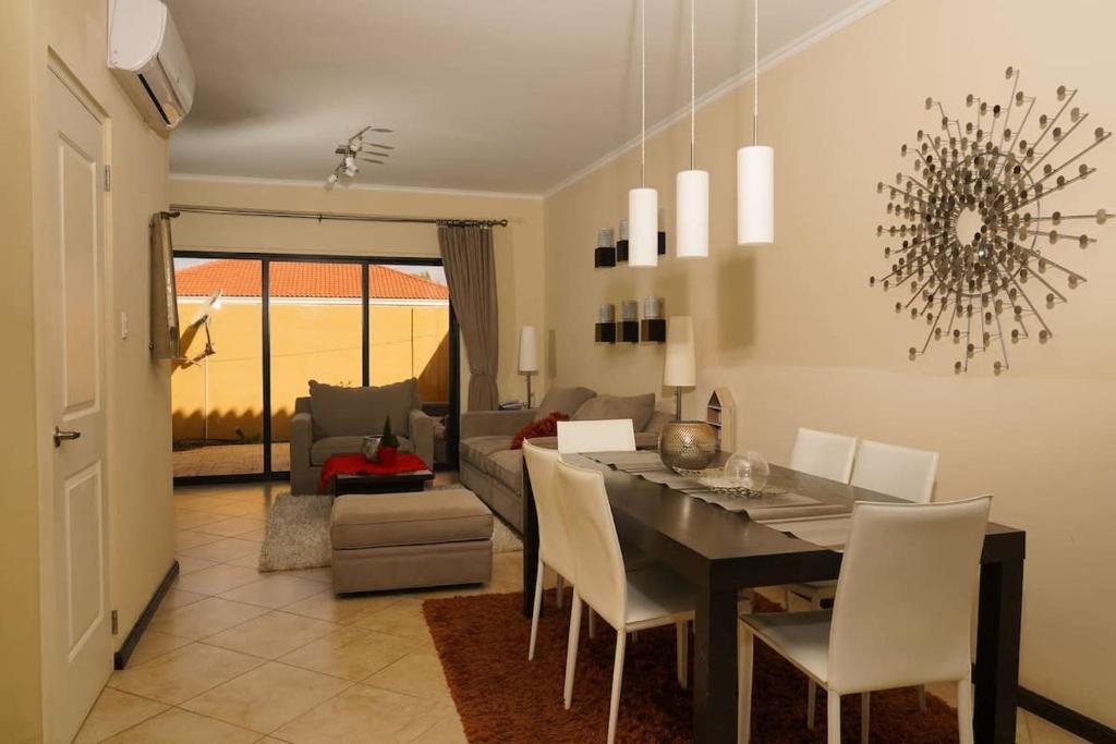 ein Esszimmer und ein Wohnzimmer mit Tisch und Stühlen in der Unterkunft Spectacular house in gold coast in Palm-Eagle Beach