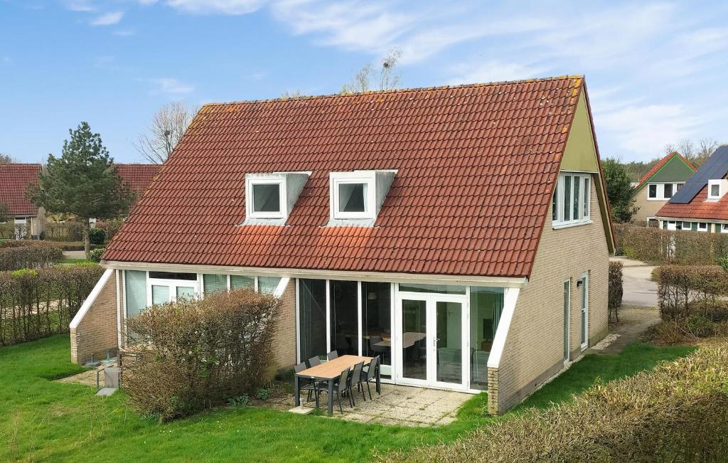 una casa con techo rojo y mesa en Stunning Home In Vlagtwedde With Kitchen, en Vlagtwedde