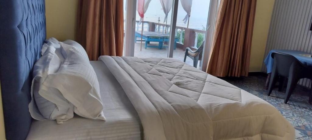 a bed with white sheets and pillows in a bedroom at Sea view Sun shine in Calangute