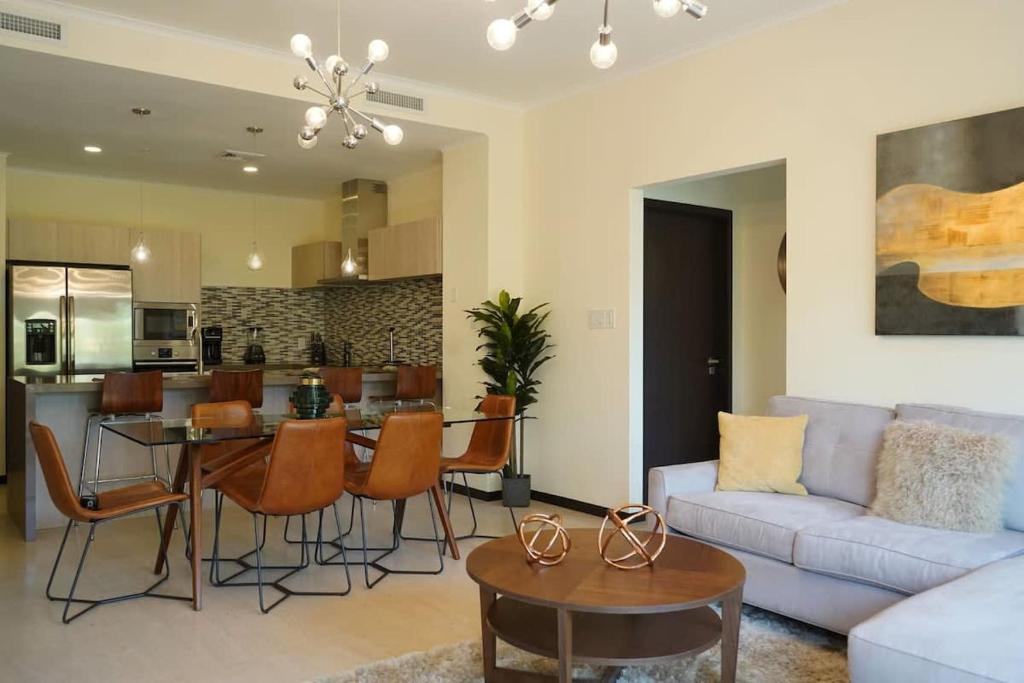 een woonkamer met een bank en een tafel bij Modern apartment in levent in front of eagle beach in Palm-Eagle Beach