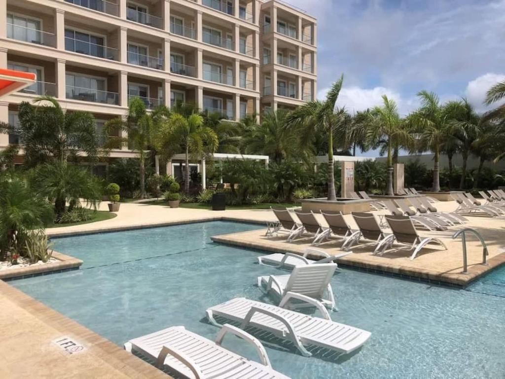 een zwembad met ligstoelen en een gebouw bij Beautiful apartment in eagle beach levent in Palm-Eagle Beach